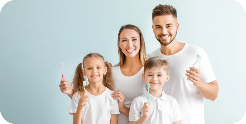 Smiling family holding toothbrushes